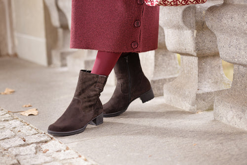 Woman sitting on a bench posing with brown boots