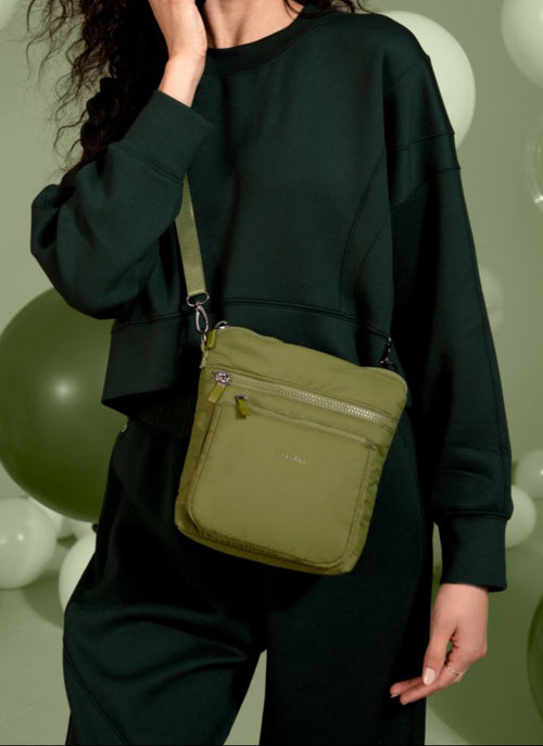Woman wearing a green Baggallini purse