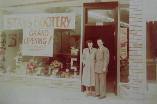 Man and woman standing outside of the Stan's Bootery Grand Opening in 1950