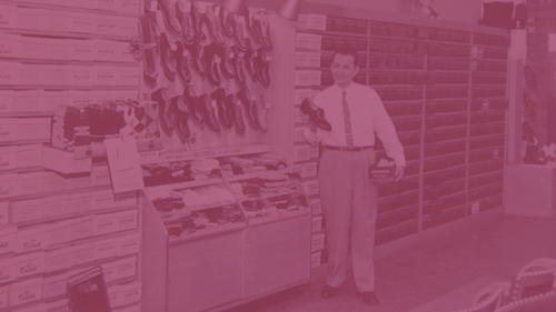 Vintage image of a man holding a shoe from 1950 with a pink overlay